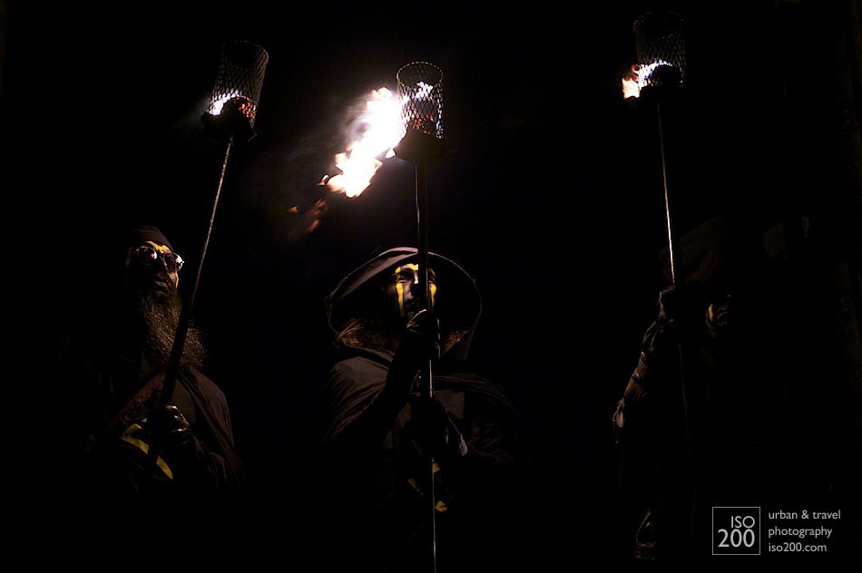 Three torch bearers wait for the beginning of the Beltane Fire Festival, Calton Hill, Edinburgh
