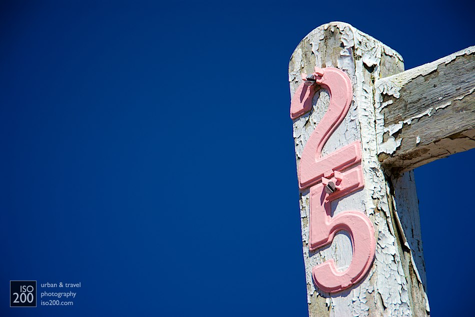 The sign for house number 25 - pink letters on an old wooden house signpost, Warwick, Bermuda