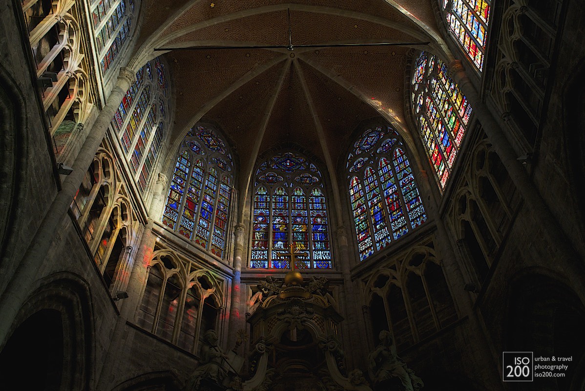 Dappled sunlight through the stained glass on the stone tracery above the apse of the Saint Bavo Cathedral (also known as Sint-Baafs Cathedral, or Sint Baafskathedraal in Dutch), Ghent, Flanders.