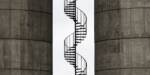 Photo of a spiral metal staircase between concrete tanks, Copenhagen.