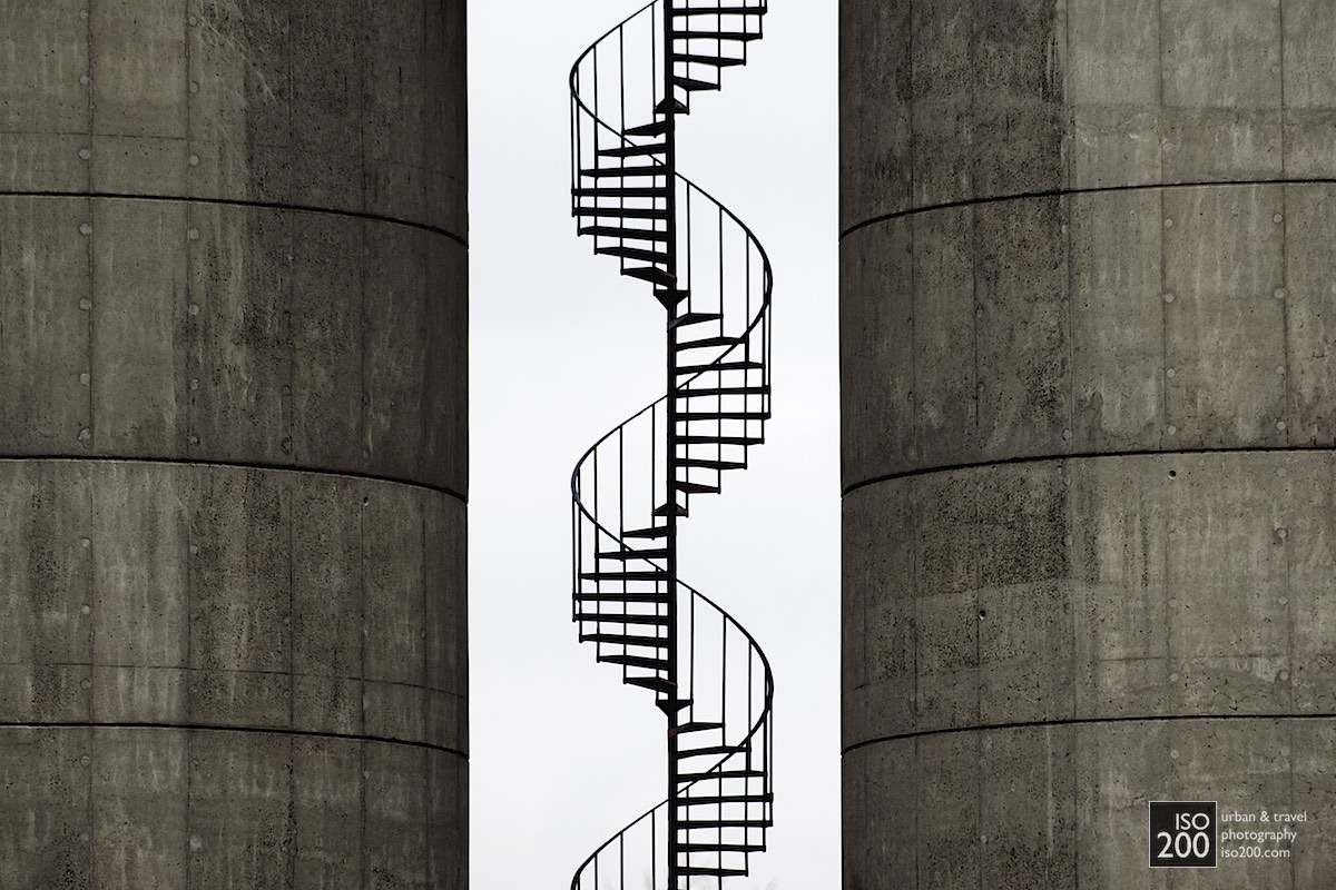 
A spiral staircase sneaks up between two cast concrete tanks, Copenhagen, Denmark.