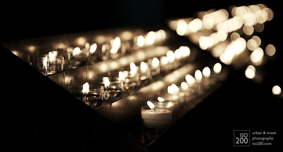 Votive candles flicker in the aisle of the Church of Our Lady, in Brugges, Flanders.