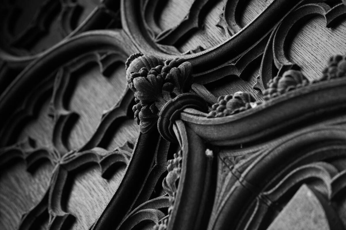 Black and white detail of elaborately carved wooden door at York Minster.
